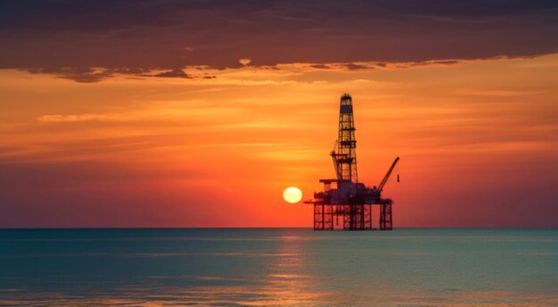 Oil rig seashore with beautiful sunset